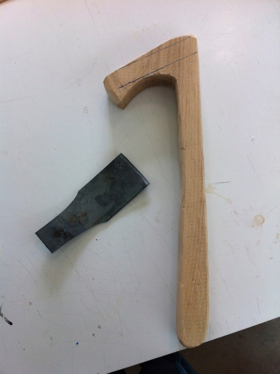 The separate parts of the wooden axe handle and sheet metal blade.
